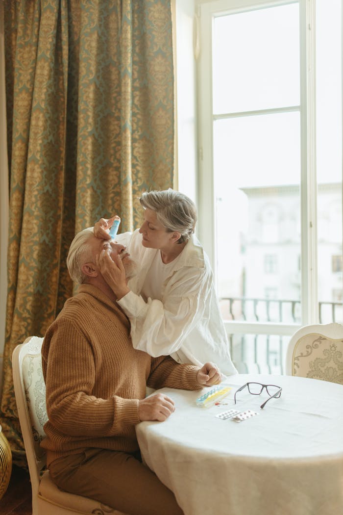 Woman Putting Liquid on Man's Eye
